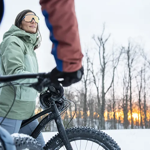 Two people with bikes in the snow
