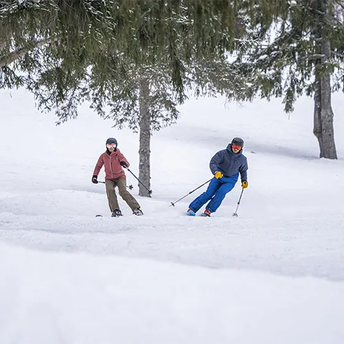 Two people skiing in the snow